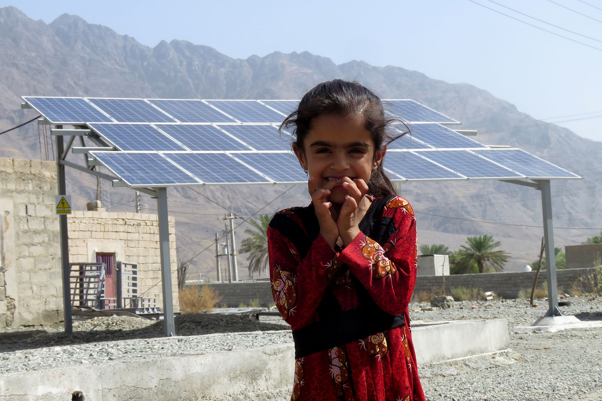 Child standing near a small solar panel installation